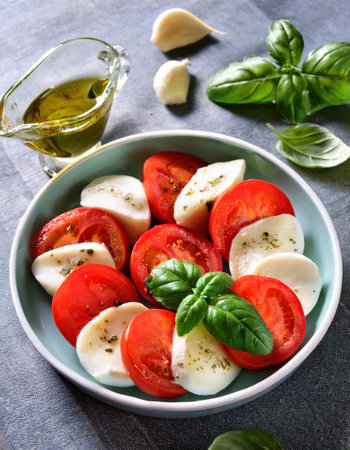 Delight in a colorful summer salad made with juicy tomatoes, creamy mozzarella, and fragrant basil.の素材