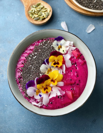A colorful smoothie bowl filled with refreshing fruits, flowers, and healthy toppings.の素材