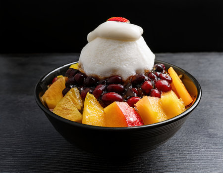 A colorful bowl filled with fresh summer fruits topped with a creamy layer and sweetness.の素材