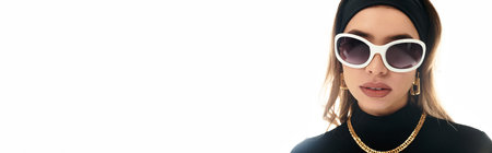 A young woman highlights her beauty with oversized sunglasses and chic accessories.の写真素材