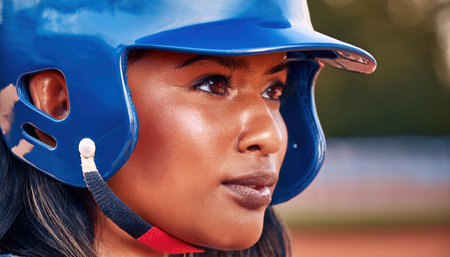 The player in the blue helmet waits intently under the warm evening sunlight.の素材