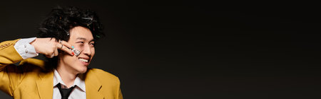 A stylish Asian man models with plaster in a modern studio, radiating confidence, bannerの写真素材