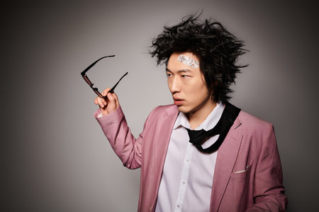 An asian man elegantly poses in a studio, displaying stylish spring fashion attire.の写真素材