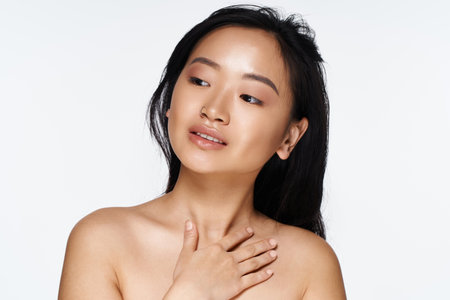 A graceful young Asian woman smiles softly, exuding confidence and natural beauty.の写真素材