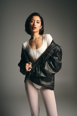 A fashionable young woman stands confidently in a stylish outfit, radiating elegance and charm.の写真素材