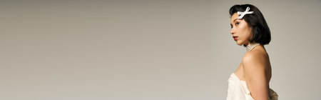 A young bride stands elegantly in a stunning white gown with a delicate accessory.の写真素材