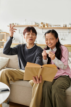 A young Asian couple relaxes together, laughing and sharing stories in their cozy living room space.