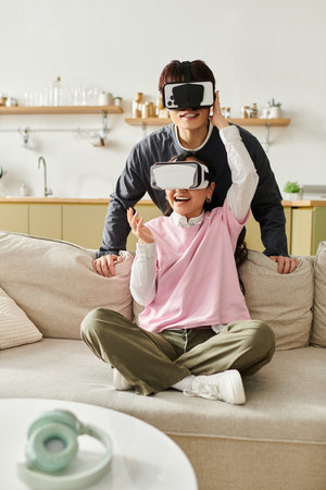 A young couple enjoys virtual reality at home, sharing laughter and joy together.の写真素材