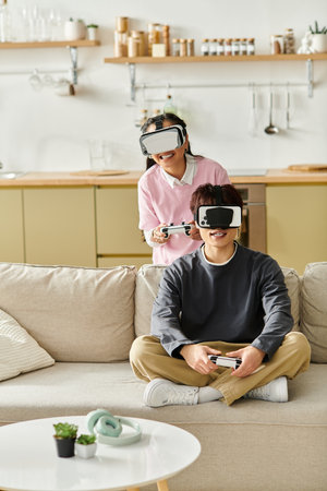 A young Asian couple engages in virtual gaming at home, sharing laughter and excitement.の写真素材