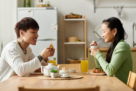 A young couple enjoys a delightful breakfast together, surrounded by cheerful sunlight.の写真素材