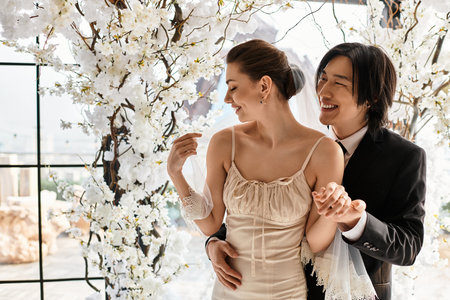 Loving couple shares a tender moment amidst beautiful blossoms, celebrating their wedding day.のeditorial素材