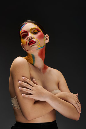 A young woman displays vibrant, artistic face makeup with bold colors and designs.の写真素材