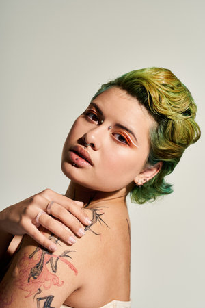A young woman with vibrant green and yellow hair shows off her unique style and makeup.のeditorial素材