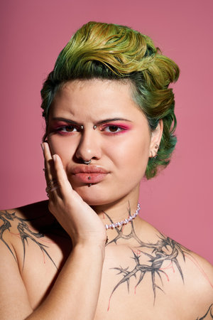 Young woman displays her unique style with vibrant hair and striking makeup in a playful pose.のeditorial素材