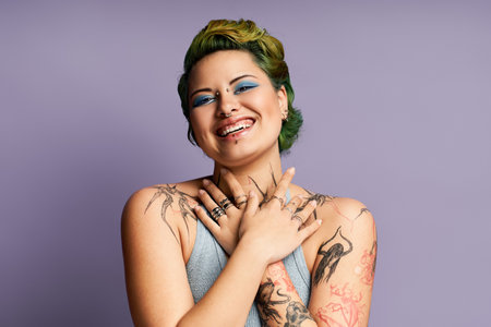 A young woman with striking makeup smiles, showcasing her fashion style and tattoos.のeditorial素材