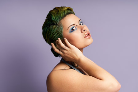 A stylish young woman with vibrant green hair poses confidently, showcasing her fashion flair.のeditorial素材