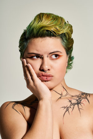 A young and beautiful woman poses confidently with vibrant green hair, expressing her unique style.のeditorial素材