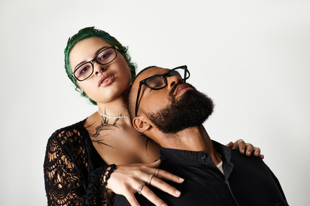 A fashionable couple showcases their unique styles while wearing sunglasses in a vibrant studio.のeditorial素材