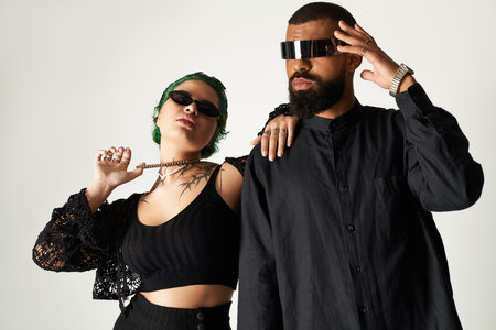 A trendy young couple models stylish outfits and sunglasses in a modern studio.のeditorial素材