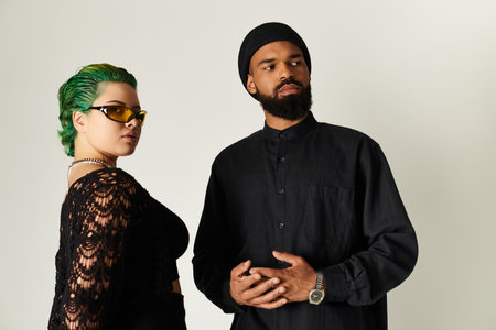 A fashionable young couple confidently poses in stylish outfits and sunglasses, exuding charisma.のeditorial素材