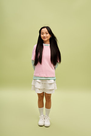 Fashionable young woman in bright casual outfit posing cheerfully.