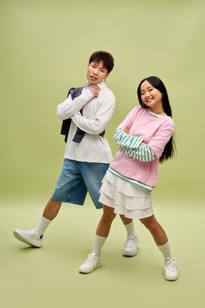 A charming couple playfully poses in stylish outfits, showcasing their connection and joy.のeditorial素材