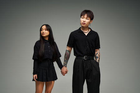 Couple stands confidently together, showcasing their fashionable outfits and strong connection.のeditorial素材