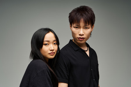 A lovely couple stands closely together, exuding style and romance in a dynamic portrait setting.のeditorial素材