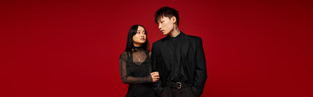 A fashionable couple stands hand in hand, embodying love and connection in a stunning setting.のeditorial素材