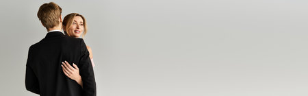 A radiant bride in a pink wedding dress embraces her groom during their spring wedding celebration, bannerの写真素材