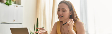 A young woman enthusiastically shares her thoughts while seated at a desk.