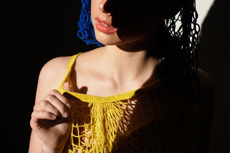 A confident young person showcases a unique outfit in a softly lit indoor space.の写真素材