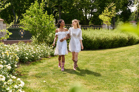 A lovely young couple strolls side by side in a vibrant garden adorned with blooming plants.の写真素材