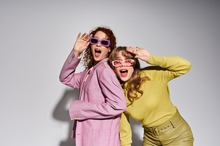 A joyful young couple showcases vibrant outfits and playful energy against a light backdrop.の写真素材