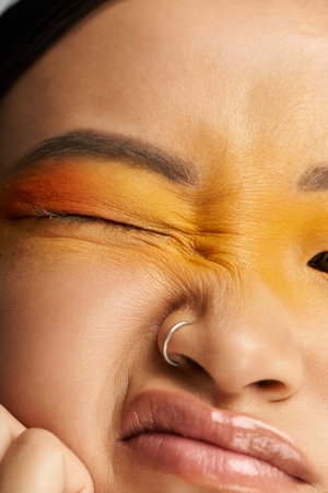 Bright colors enhance a young Asian womans face, expressing her artistic individuality.