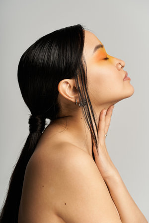 A beautiful young Asian woman poses elegantly, showcasing her striking makeup artistry.の写真素材