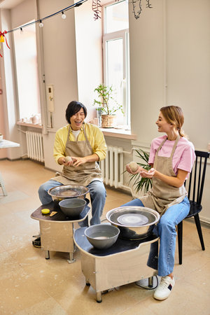 A young couple enjoys crafting pottery together in a cozy and artistic studio atmosphere.
