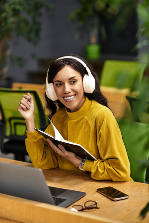 Elegant woman enjoys a captivating moment of inspiration while working diligently in her office.
