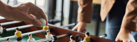 Two coworkers enjoy a competitive foosball game in the office, promoting camaraderie and fun.の写真素材