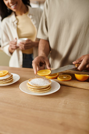 A couple shares a cozy morning at home, happily making pancakes together.