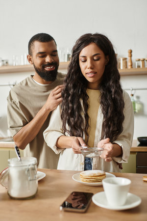 A couple enjoys a warm moment together in their inviting kitchen while making breakfast.のeditorial素材