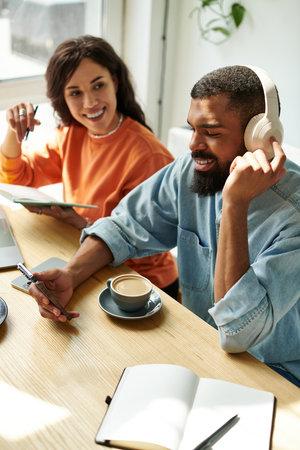 An African American couple engages in remote work, sharing ideas and creativity in a charming cafe.