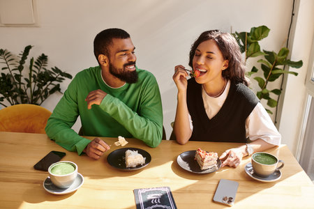 Two individuals share smiles and tasty dishes at a serene cafe, enjoying their time together.の写真素材