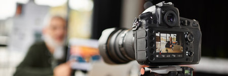 A professional camera focuses on capturing vibrant moments in a busy office environment.