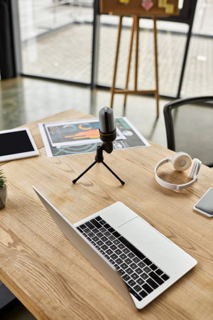 A modern office features a laptop, mic, headphones, and graphs to inspire productivity.の写真素材
