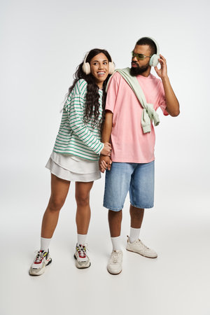 A couple enjoys a lighthearted moment, dressed in trendy outfits, radiating love and joy.