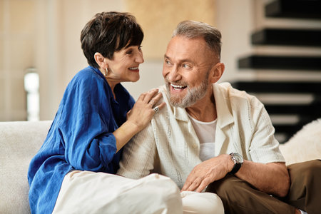 Middle aged husband and wife share joyful moments at home, surrounded by warmth and love.の写真素材