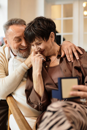 Middle aged couple shares a joyful and intimate moment at home, embracing each other warmly.
