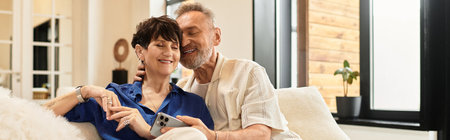 A middle aged couple enjoys quality time together, sharing smiles and affection at home, bannerの写真素材