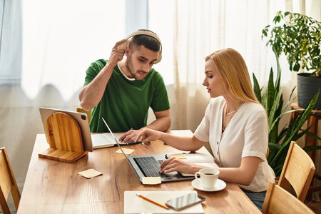 Couple enjoys quality time together at home, engaged in a collaborative work session while smiling.